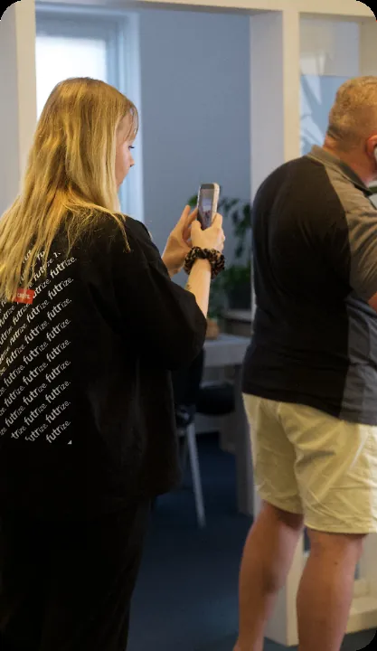 Zwei Personen filmen mit dem Smartphone in einem Büro