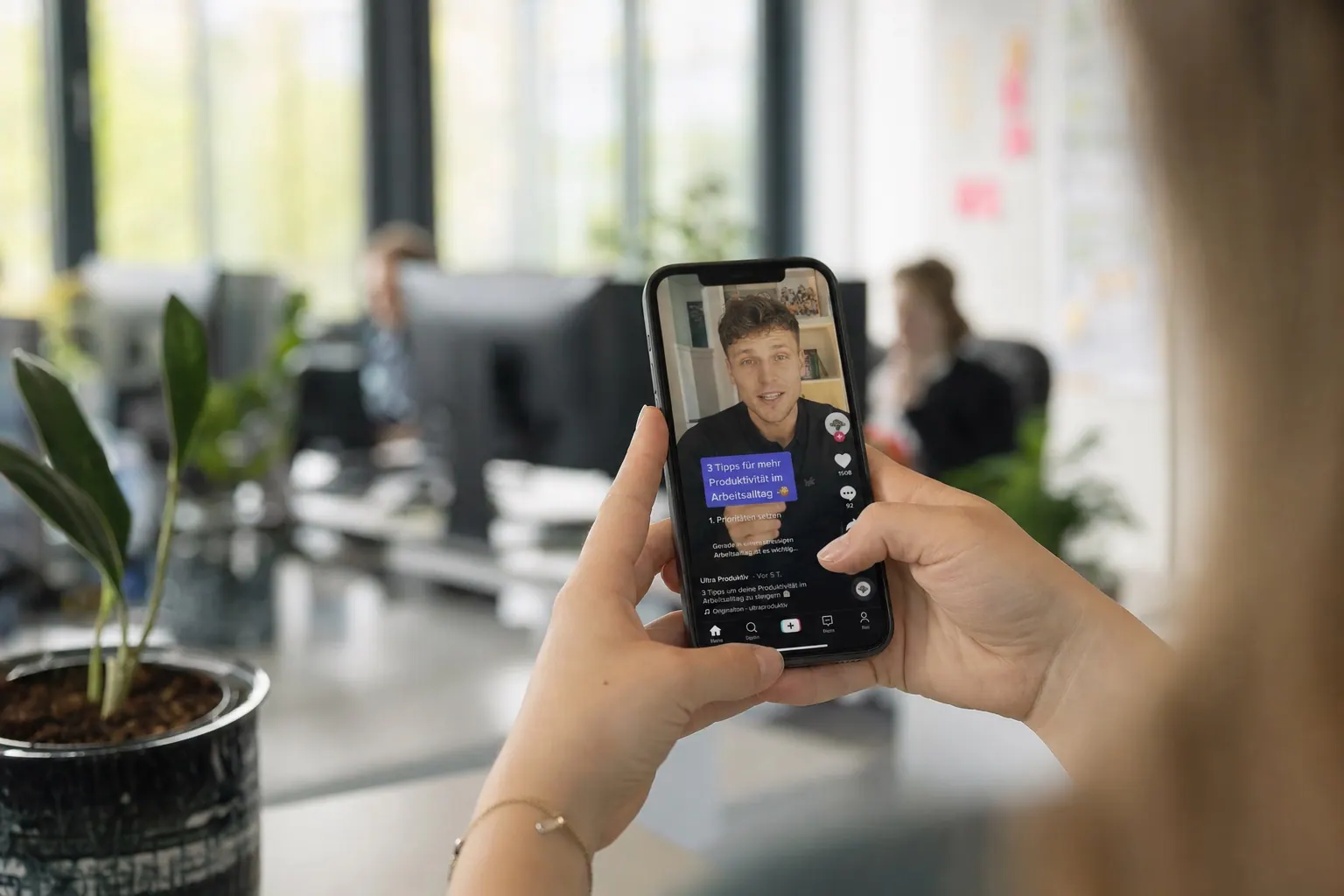 Smartphone displaying TikTok business content in German office environment